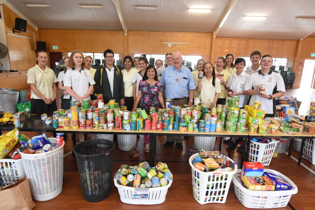 Giving: Susie Ploder and Deacon Vince Ryan with year nine St Clare's students as they prepared Christmas hampers for those in need. Photo: Scott Calvin. 