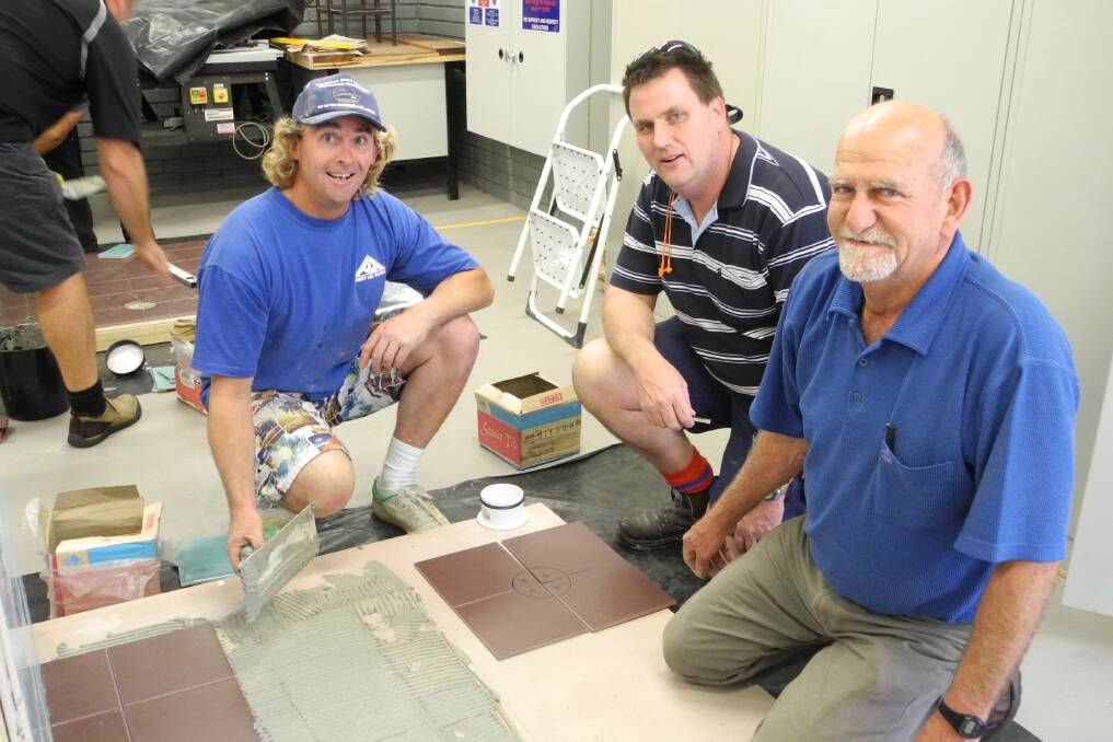 Tiler Terry Lee helps Greg Glanville, head teacher at Great Lakes College and Wingham High School industrial teacher Dave Irvine brush up on their tiling skills.